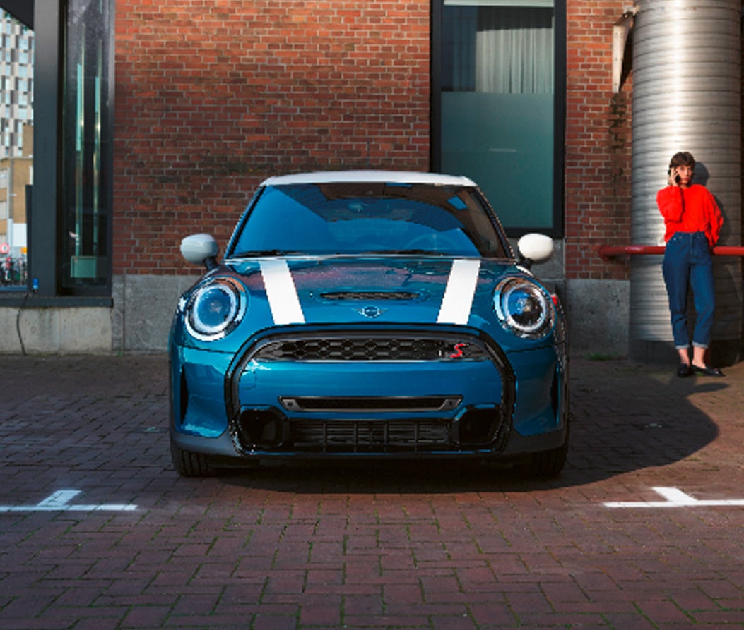 Vista frontal del MINI Hardtop 4 Puertas aparcado delante de un edificio de ladrillo.